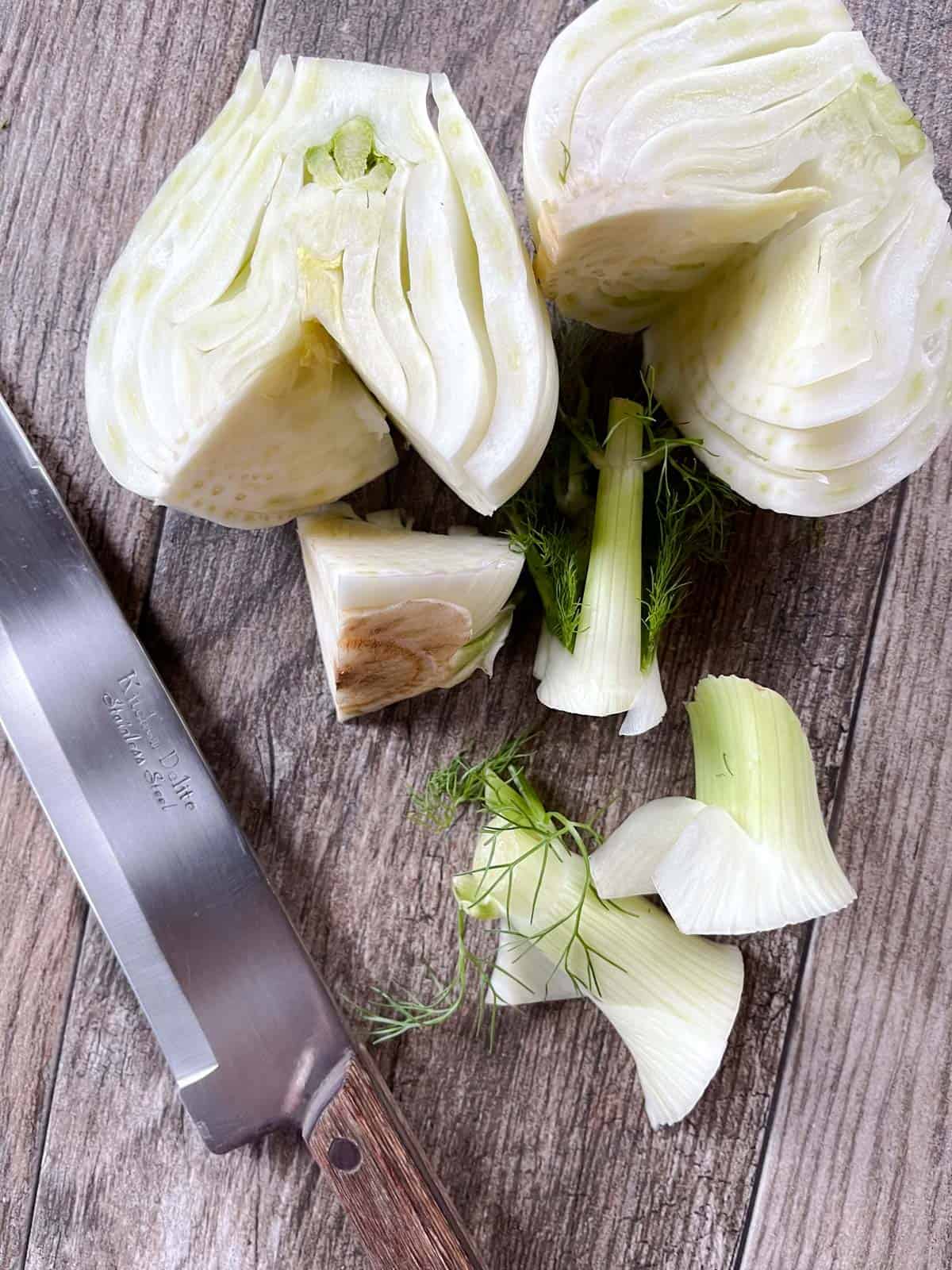 Prepared cut fennel bulb on a cutting board with a knife.