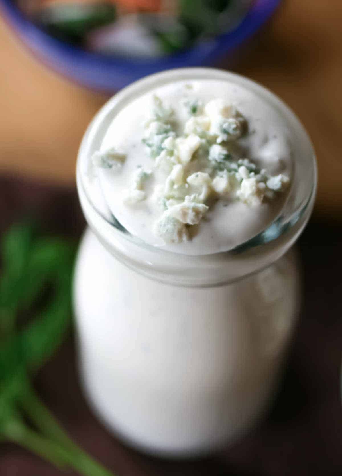 Top of bottle of keto blue cheese dressing showing chunks of blue cheese.