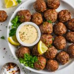 Corned beef meatballs on a white plate with horseradish mustard dipping sauce.