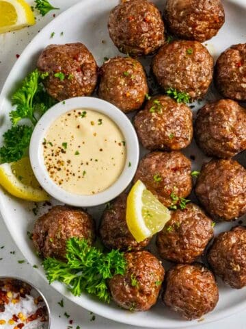 Corned beef meatballs on a white plate with horseradish mustard dipping sauce.