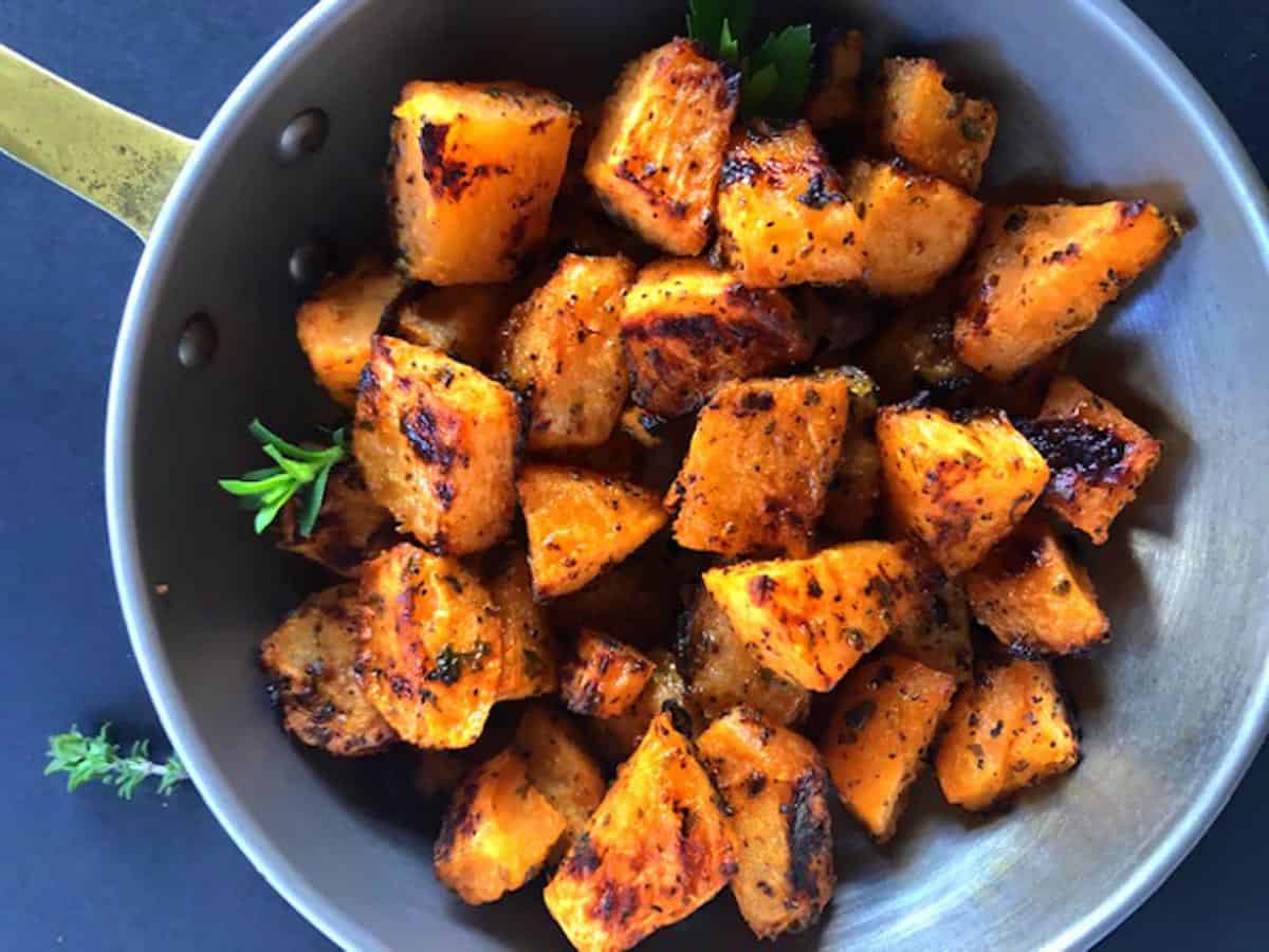 Skillet of roasted rutabagas with herbs and garnish.