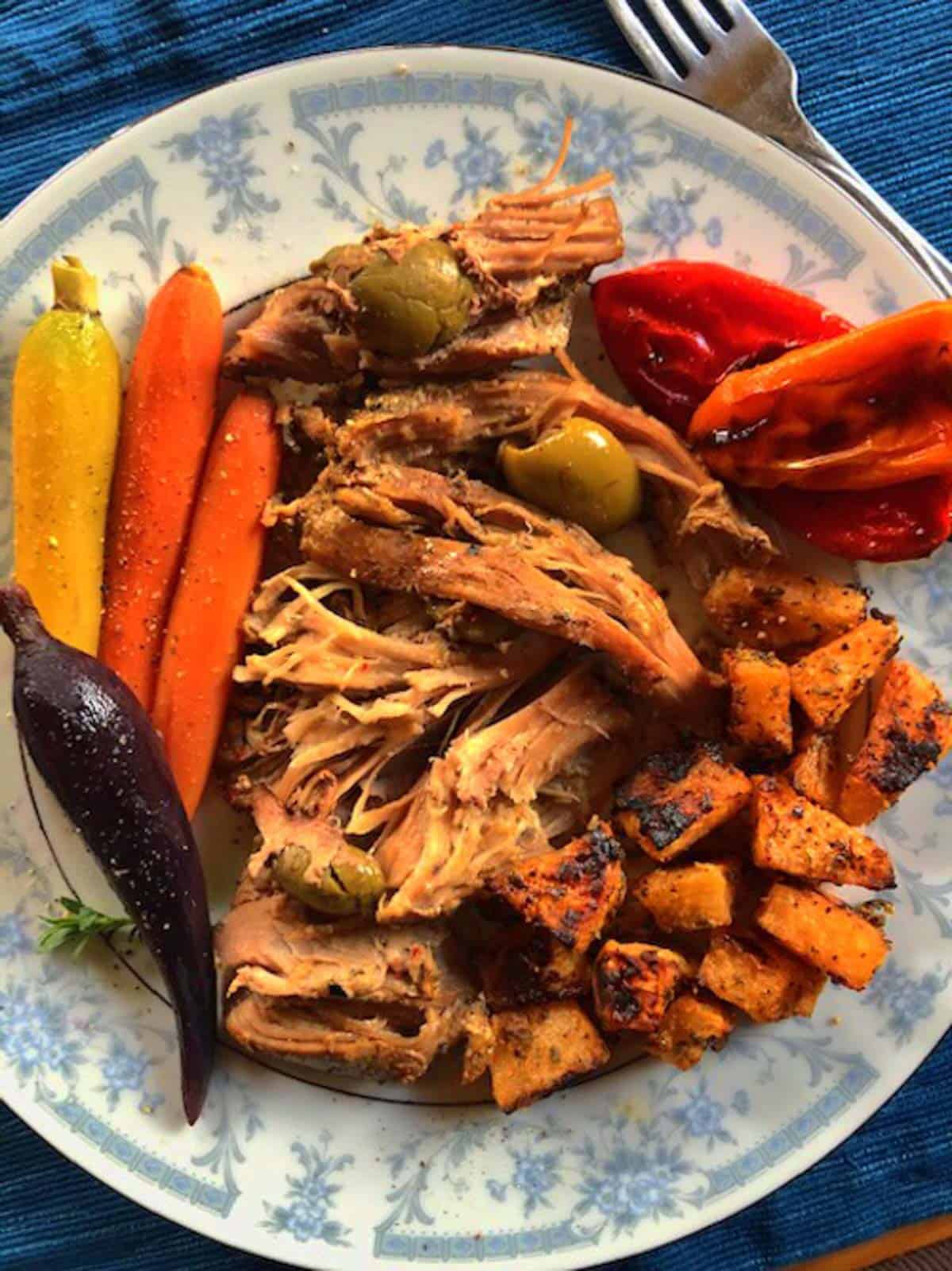 Plate of olive stuffed balsamic turkey thighs with roasted carrots and peppers and herb roasted rutabagas.