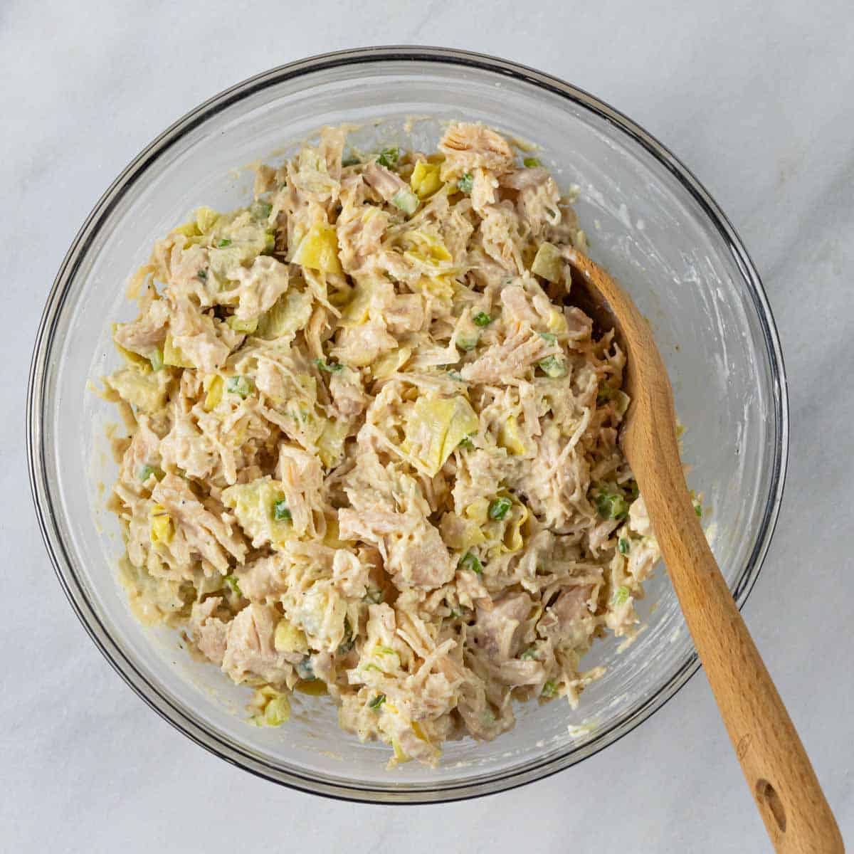 Low-FODMAP spicy chicken salad with jalapeños mixed ingredients in a glass bowl.