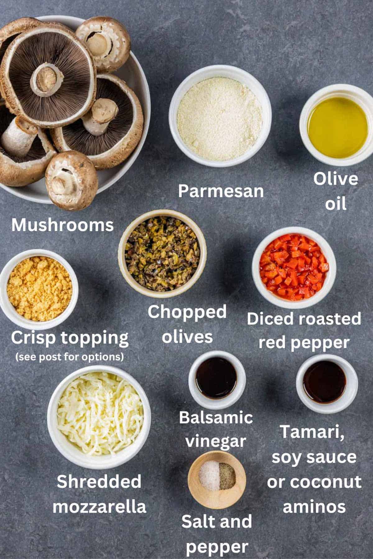Ingredients for keto stuffed mushrooms in ramekins on a grey board with white text labels.