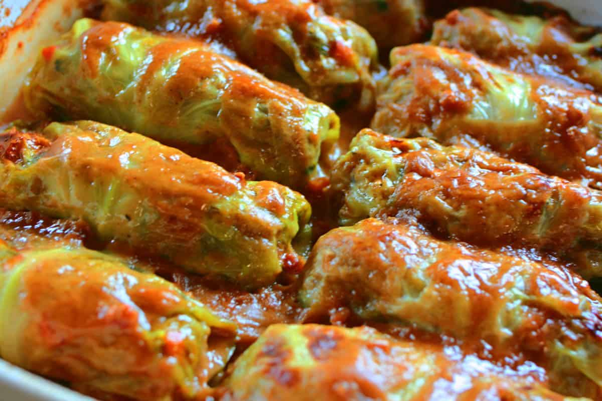 Baked homemade Asian Cabbage Rolls fresh from the oven lined up in two rows in the baking dish.