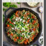 Ground chicken stir fry in a cast iron skillet garnished with dill, green onion and feta cheese.