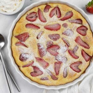 Low carb berry clafoutis fully baked in a tart dish sprinkled with keto sweetener.