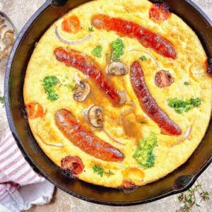 Skillet of toad in the hole with gravy poured on top.