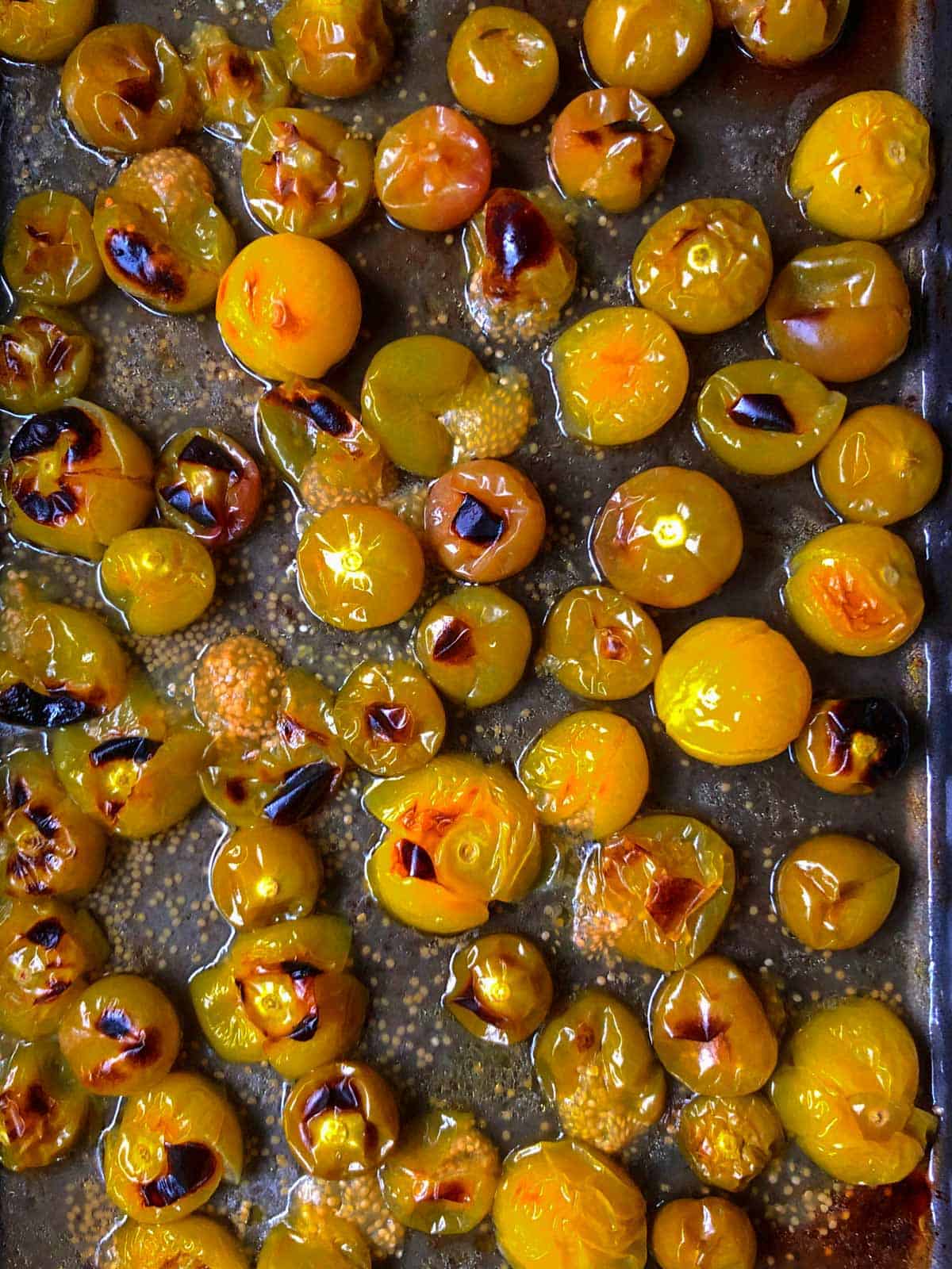 Roasted tomatillos on a baking sheet just out of the oven.