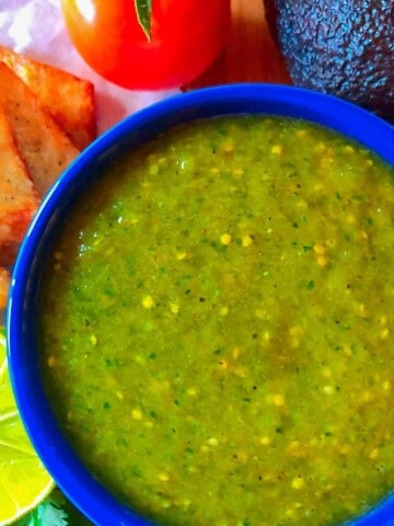 Tomatillo salsa verde in a blue bowl with a side of keto chips.