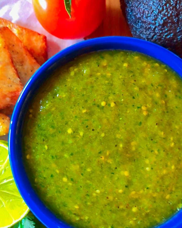 Tomatillo salsa verde in a blue bowl with a side of keto chips.