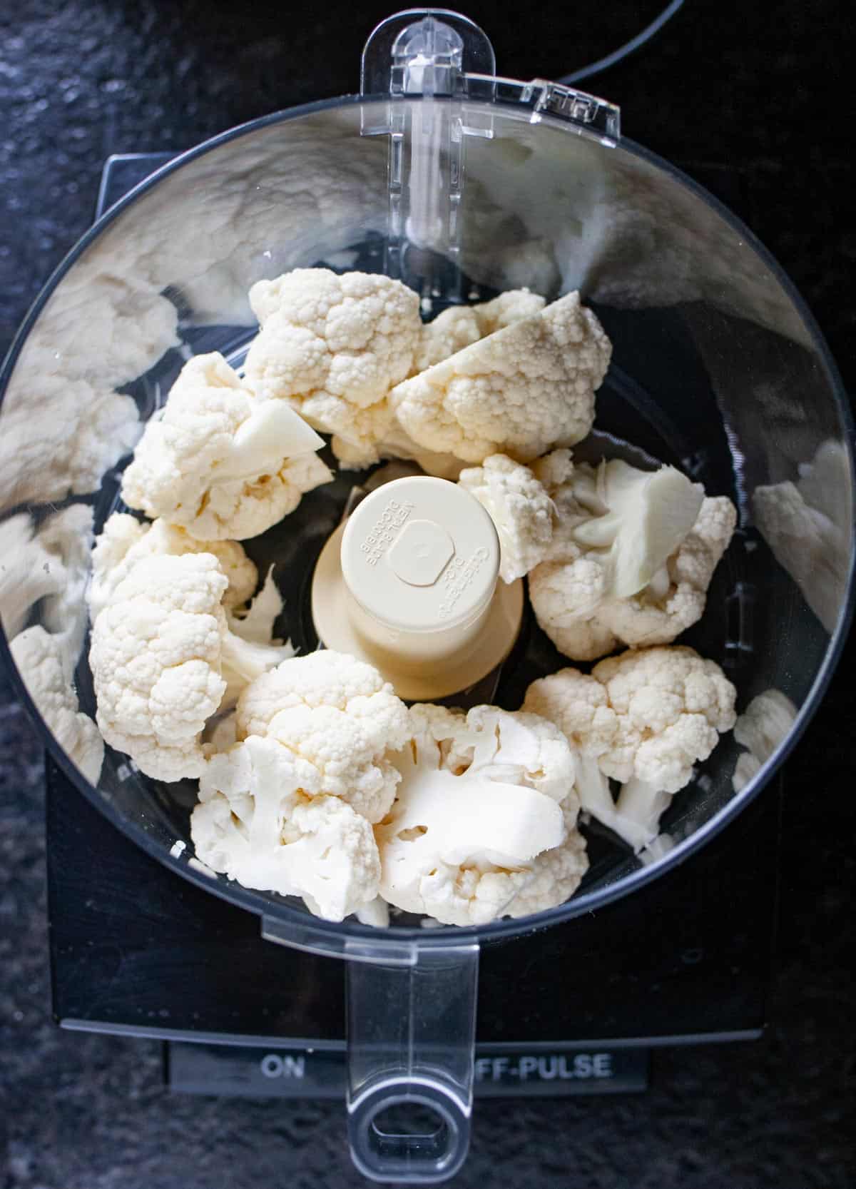 Overhead view of nine fresh florets in a food processor ready to process.