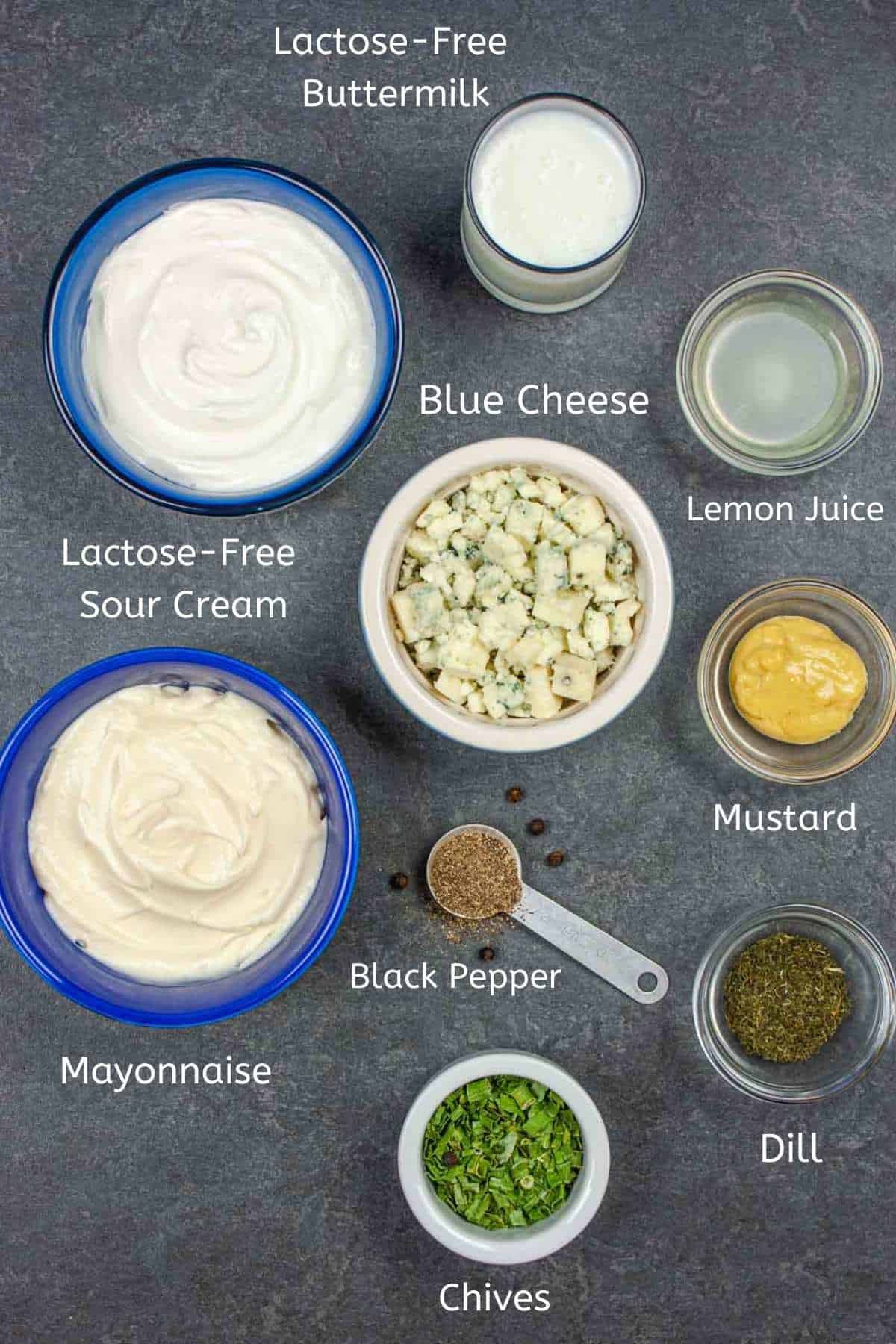 Dressing ingredients in small bowls with text labels under each on a gray background.