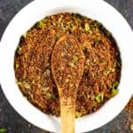 Taco seasoning in a small bowl with small wooden spoon in the center covered in spice.