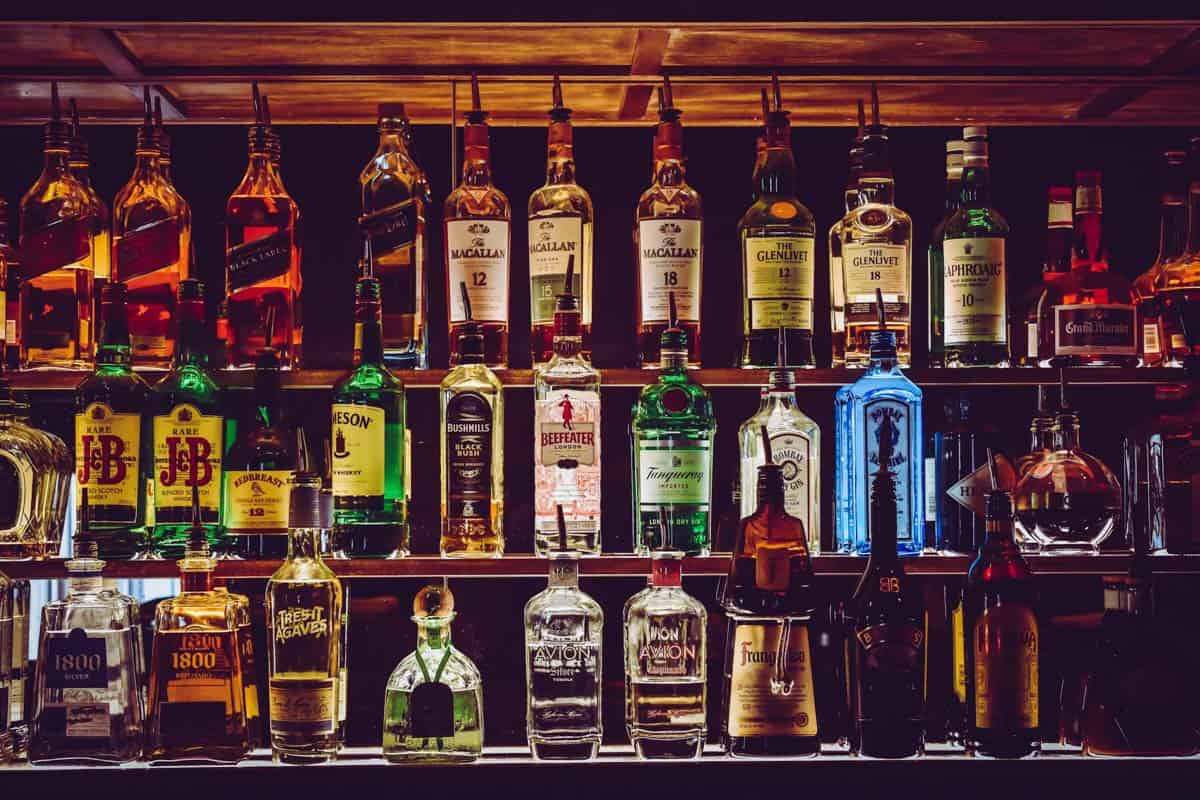 A brightly lit bar with several bottles of hard alcohol. 