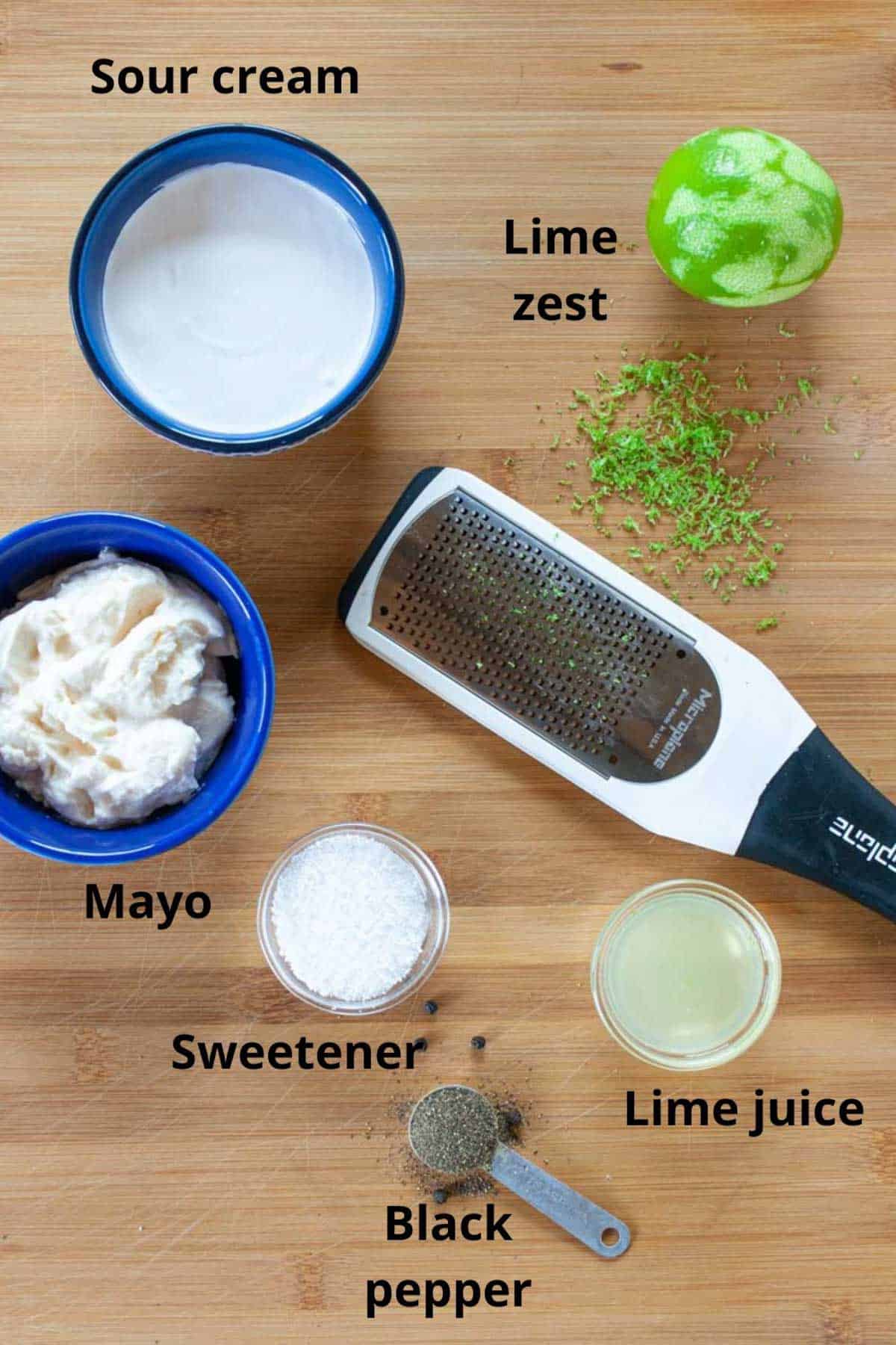 Ingredients for keto coleslaw dressing laid on a board and labelled.