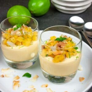 Pina colada panna cotta in serving glasses topped with pineapple salsa and toasted coconut.