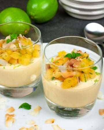 Pina colada panna cotta in serving glasses topped with pineapple salsa and toasted coconut.