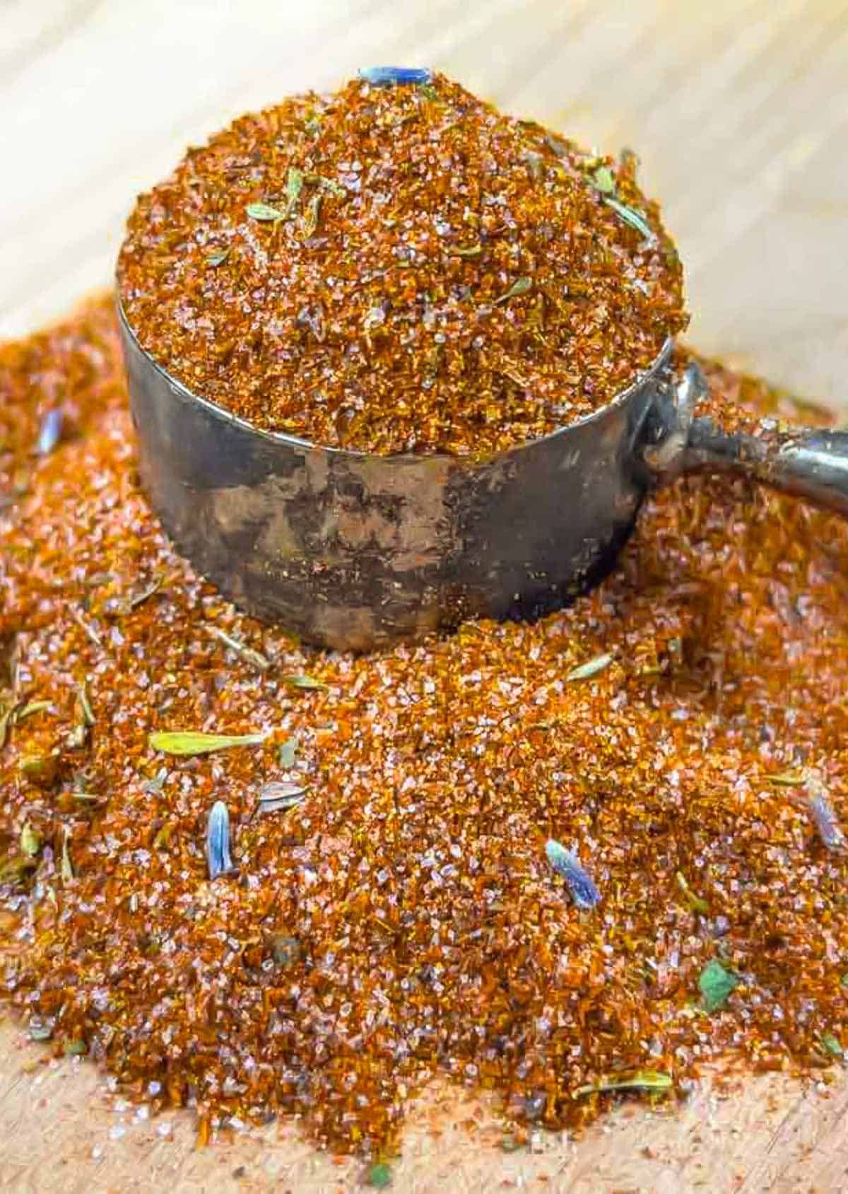 Pile of low-fodmap barbecue rub on a board with a scoop full of rub sitting on the pile.
