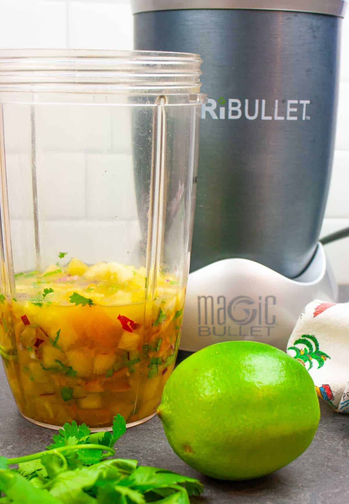 Sauce ingredients in a Nutribullet cup with blender ready to blend.