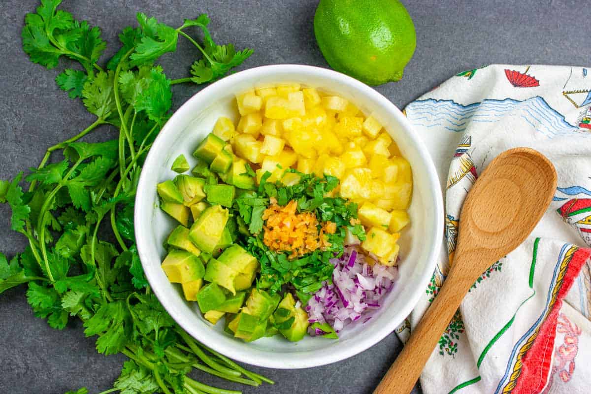 Ingredients for salsa in a white bowl ready to combine.