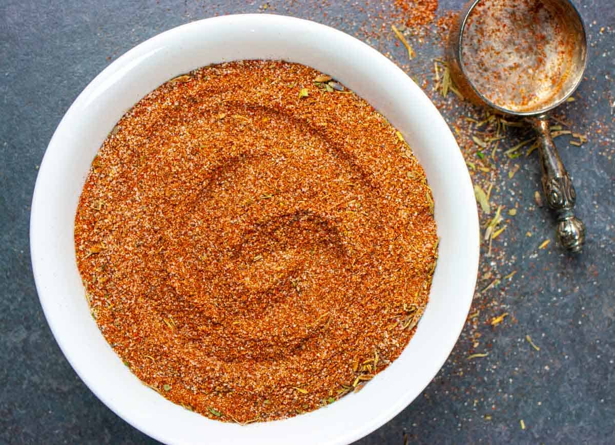 Low-fodmap barbeque rub in a bowl with a scoop on the side.