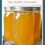 Three quart jars of finished chicken bone broth, two behind and one in front with a grey napkin in front and a carrot bunch behind.