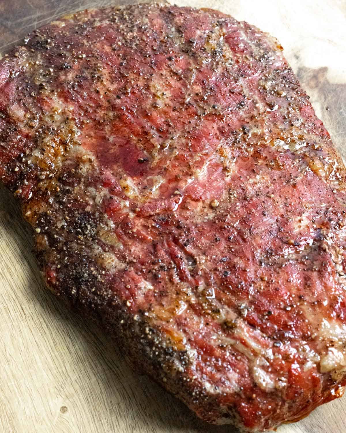 Resting smoked flank steak on a board.