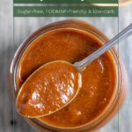 Looking down into top of glass jar of barbecue sauce with a spoonful balanced across the jar.