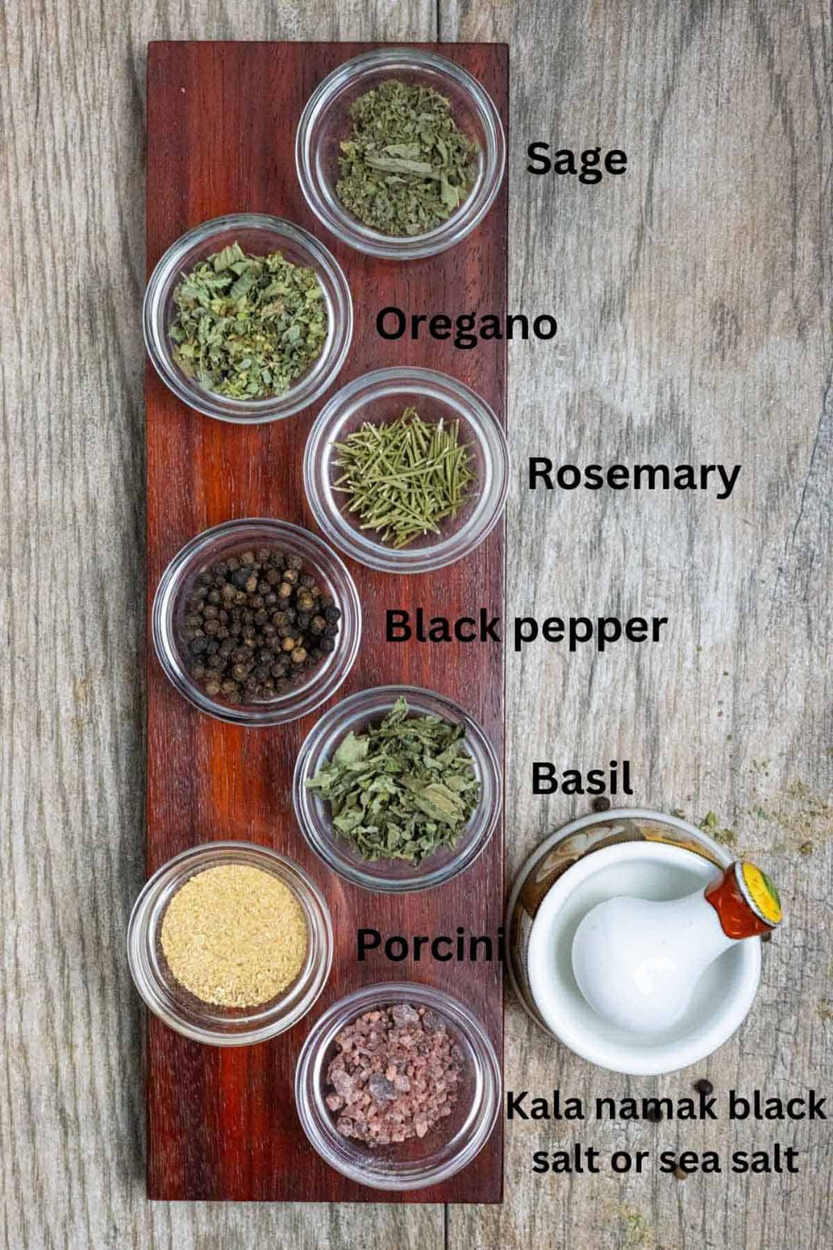 Ingredients for seasoning in small glass bowls in a vertical row with black text labels.