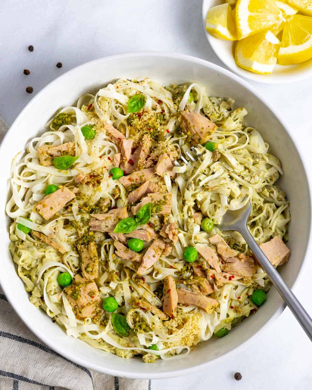 Tuna pesto pasta in a bowl with a forkful of noodles.