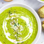 Decorated bowl of soup with a side of bread and small ramekin of salt.