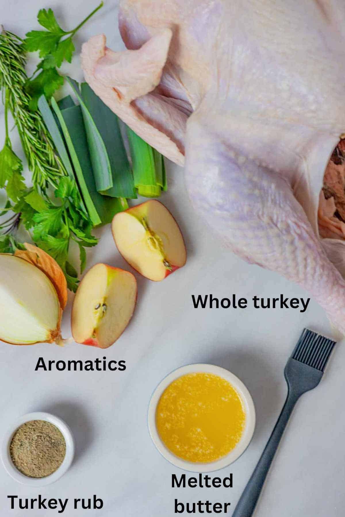 Ingredients for roasted turkey on a marble board with black text labels.