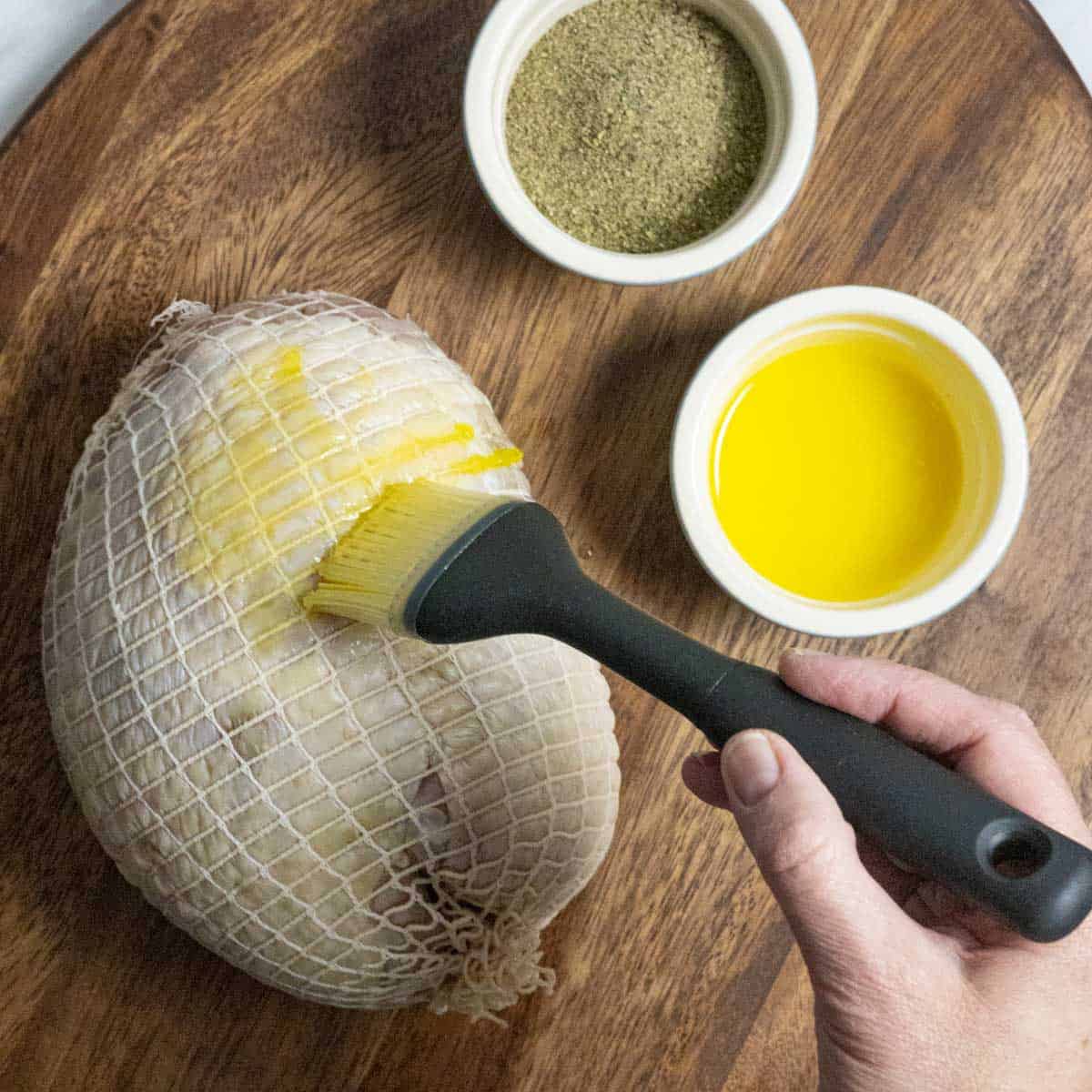 Brushing butter on the entire surface of the breast with a basting brush.