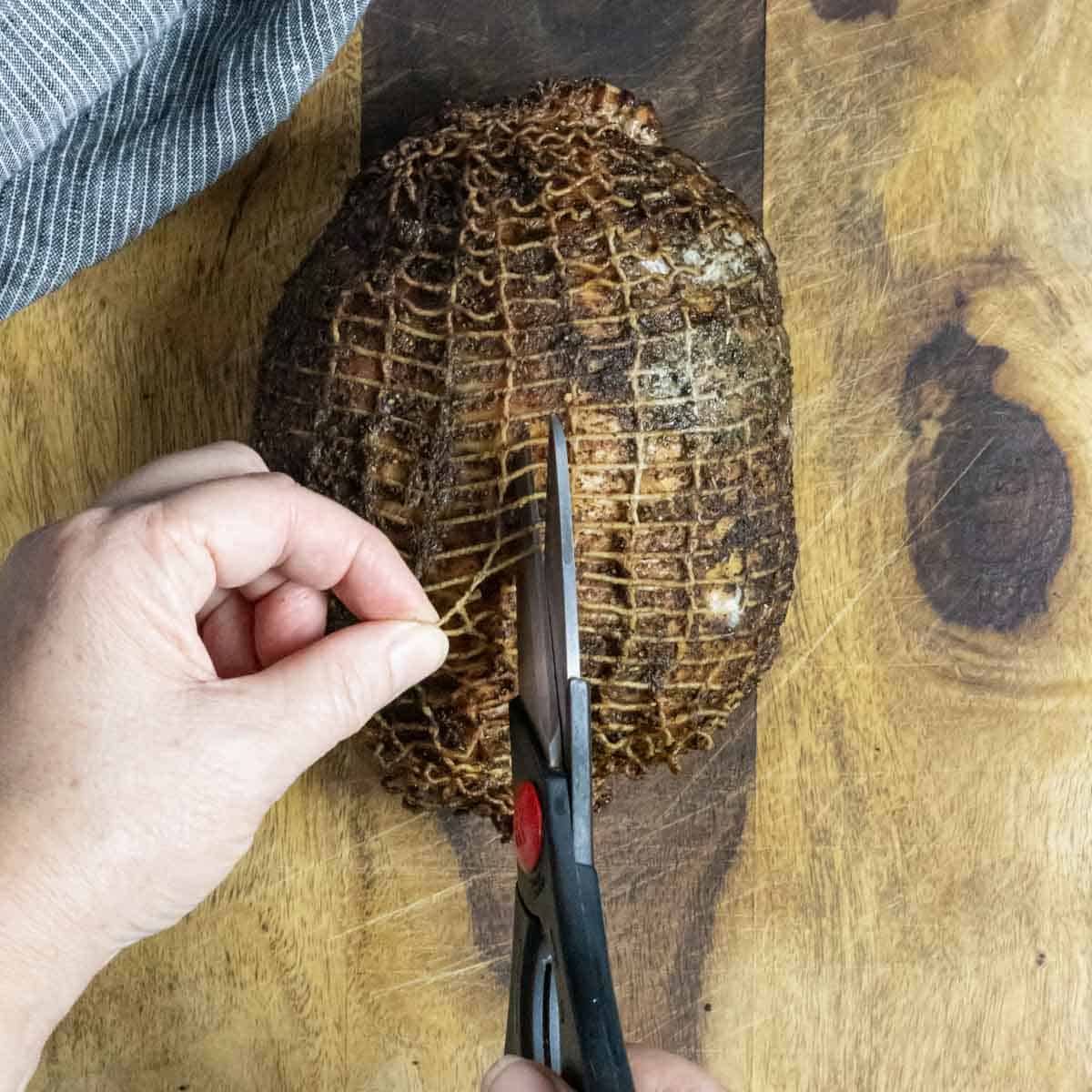 Trimming netting off of finished traeger turkey breast.