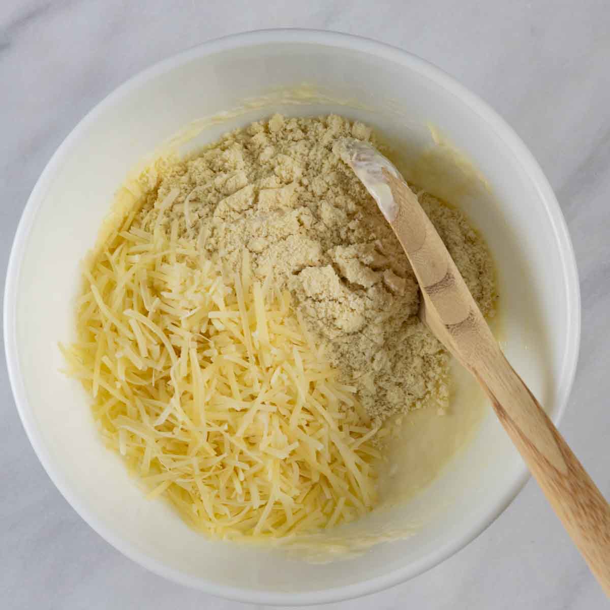 Dry ingredients, parmesan cheese in mixing bowl for qull-apart rolls.