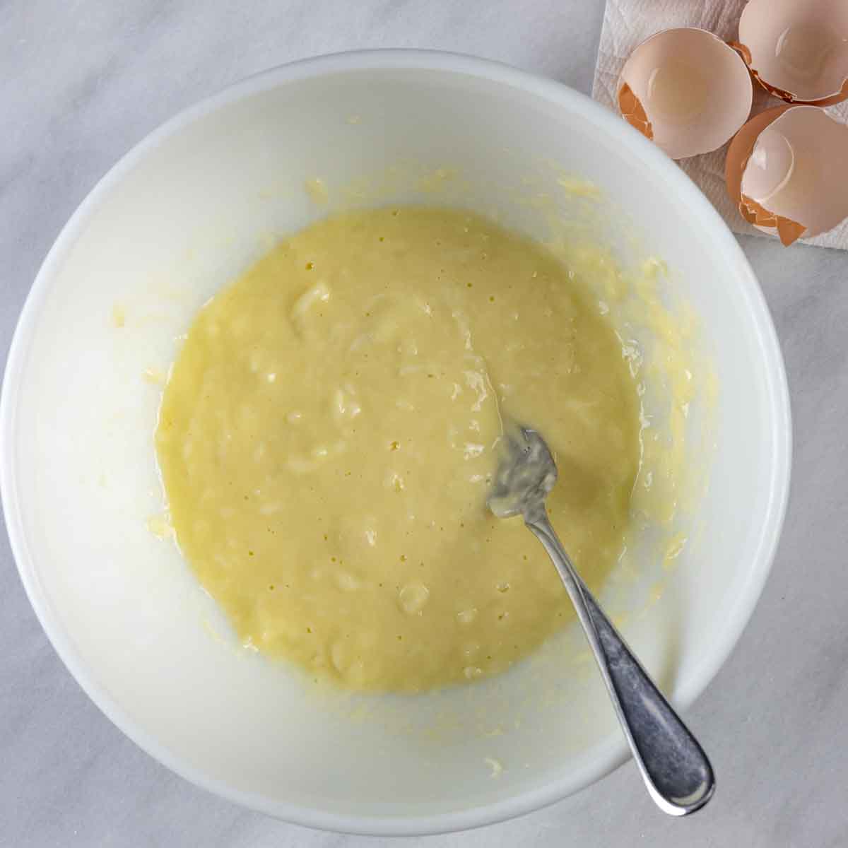 Eggs stirred into cheese ingredients.