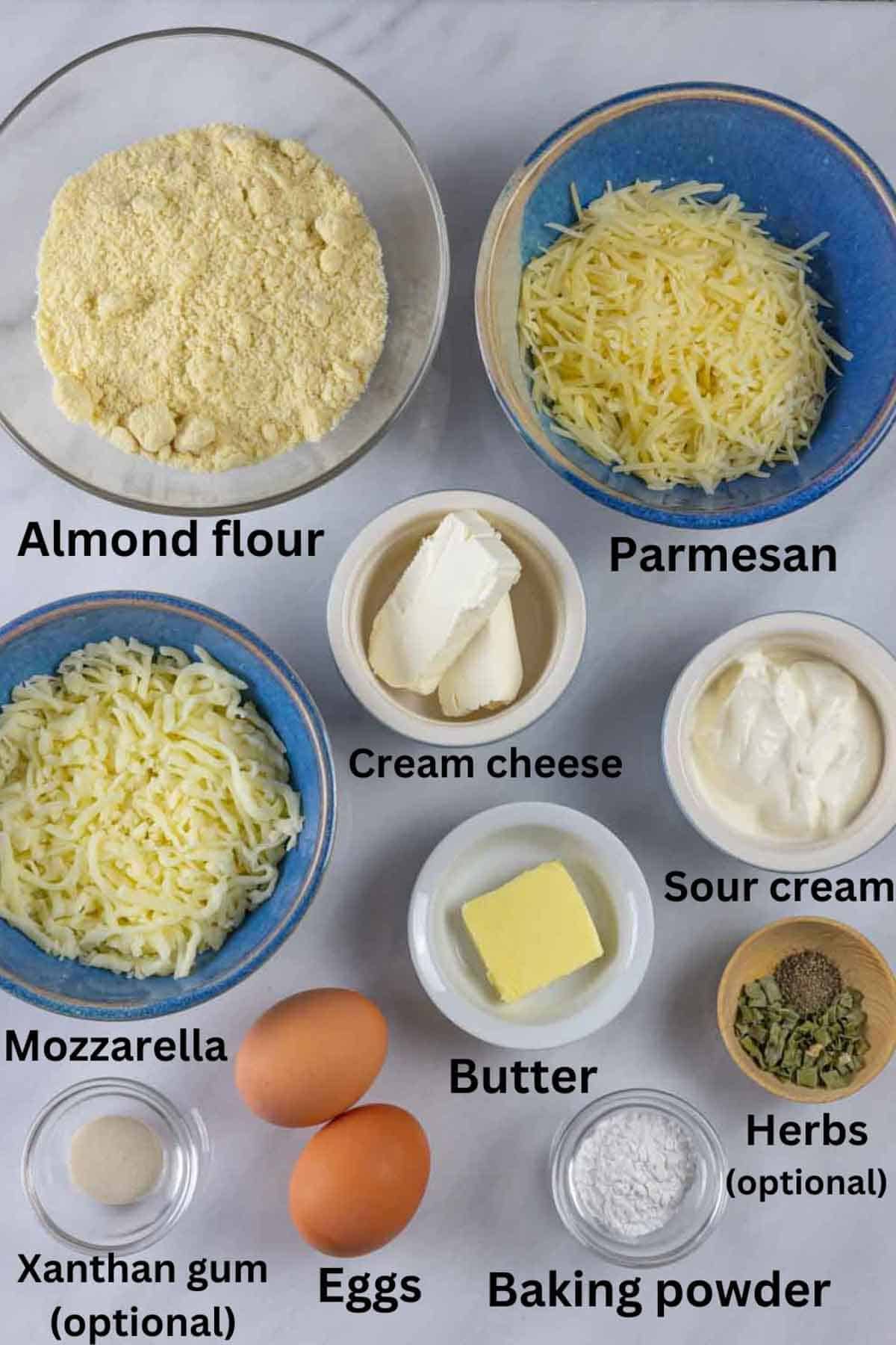 Ingredients for gluten-free dinner rolls in bowls with black text labels under each.