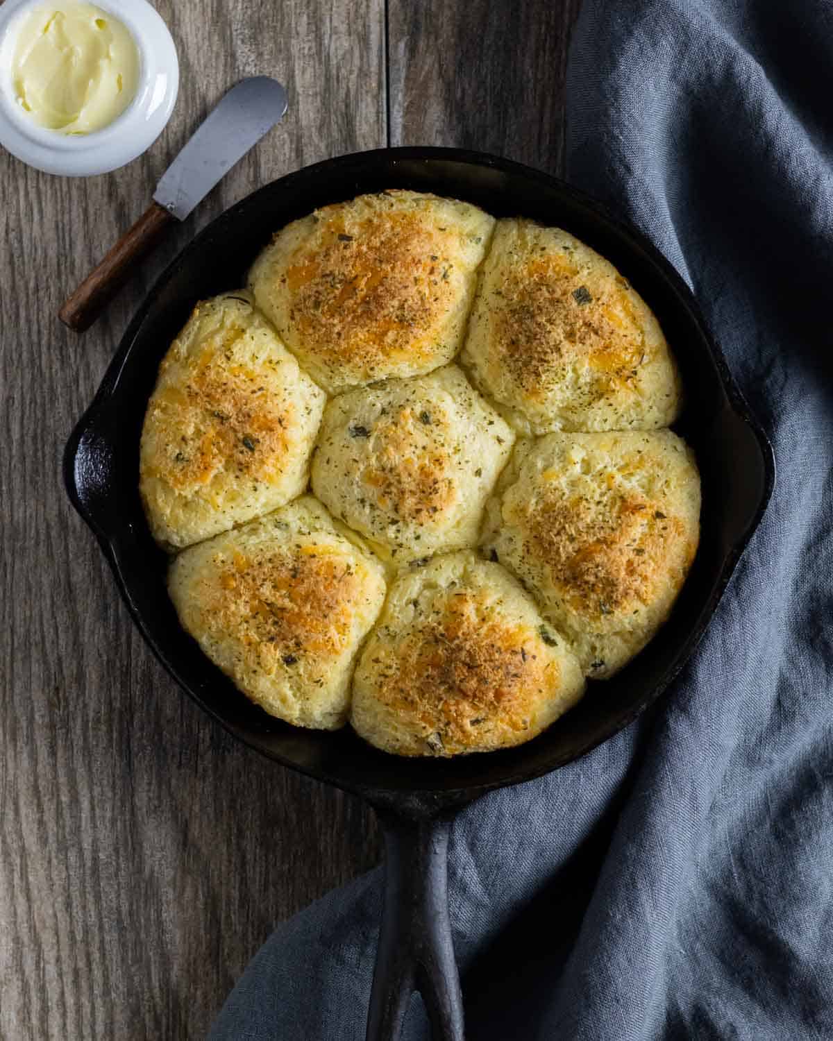Baked almond flour dinner rolls in a round pinwheel shape in a skillet.