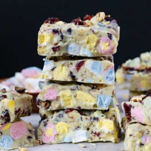 White chocolate rocky road squares stack of four with blue, pink and yellow marshmallows.