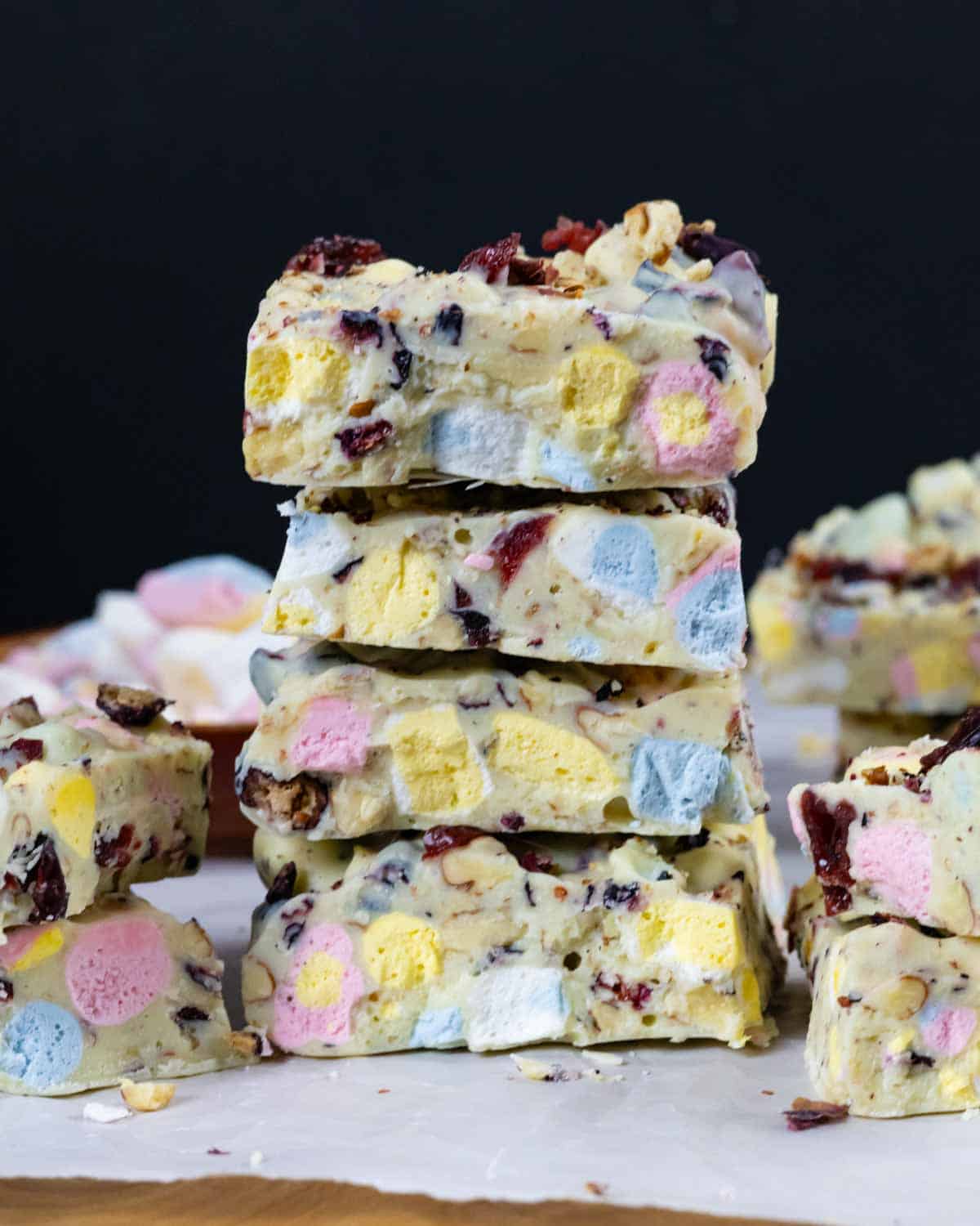 Stack of rocky road squares showing colorful marshmallows and toppings.