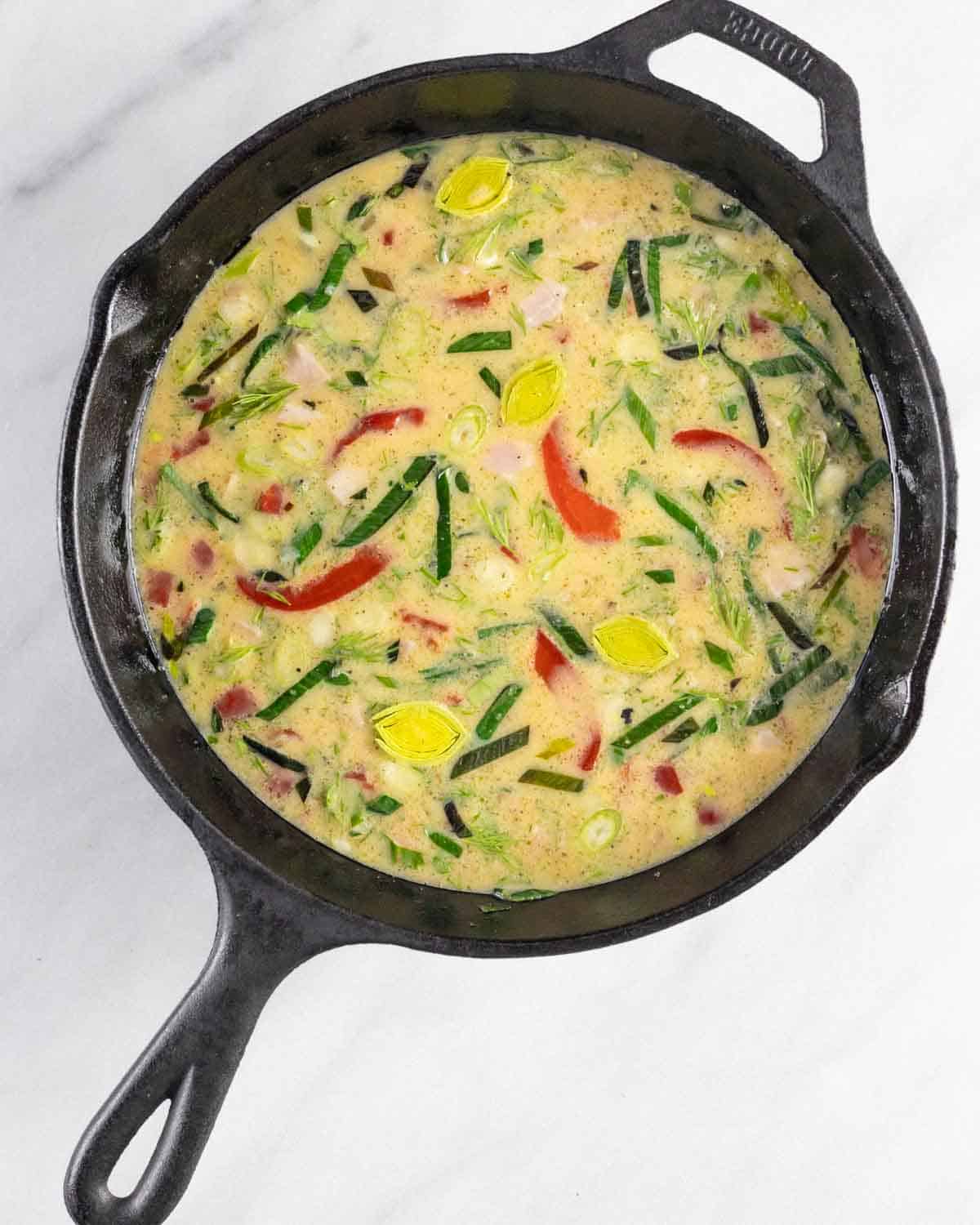 Dairy-free Frittata ingredine mixture poured into a cast iron skillet ready to bake.