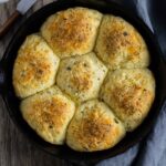 Baked almond flour dinner rolls in a round pinwheel shape in a skillet.