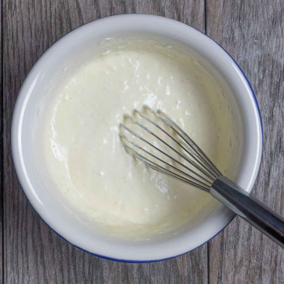 Horseradish mustard sauce ingredients whisked in a bowl.