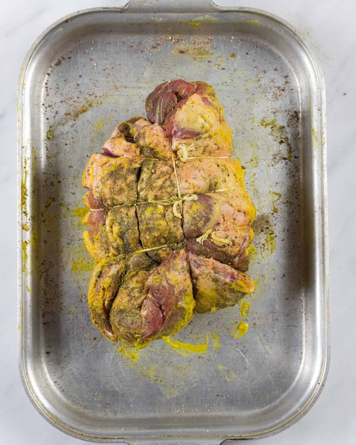 Boneless lamb roast seasoned and tied with butchers twine into tight form.
