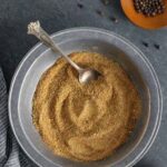 Beef rub seasoning in a pewter bowl with a decorative swirl and spoon.