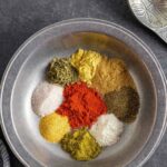 Each colorful ingredient for beef rub in a small pile inside a pewter bowl.