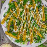 Roasted baby corn microgreen salad topped with cotija cheese and drizzle of crema dressing.