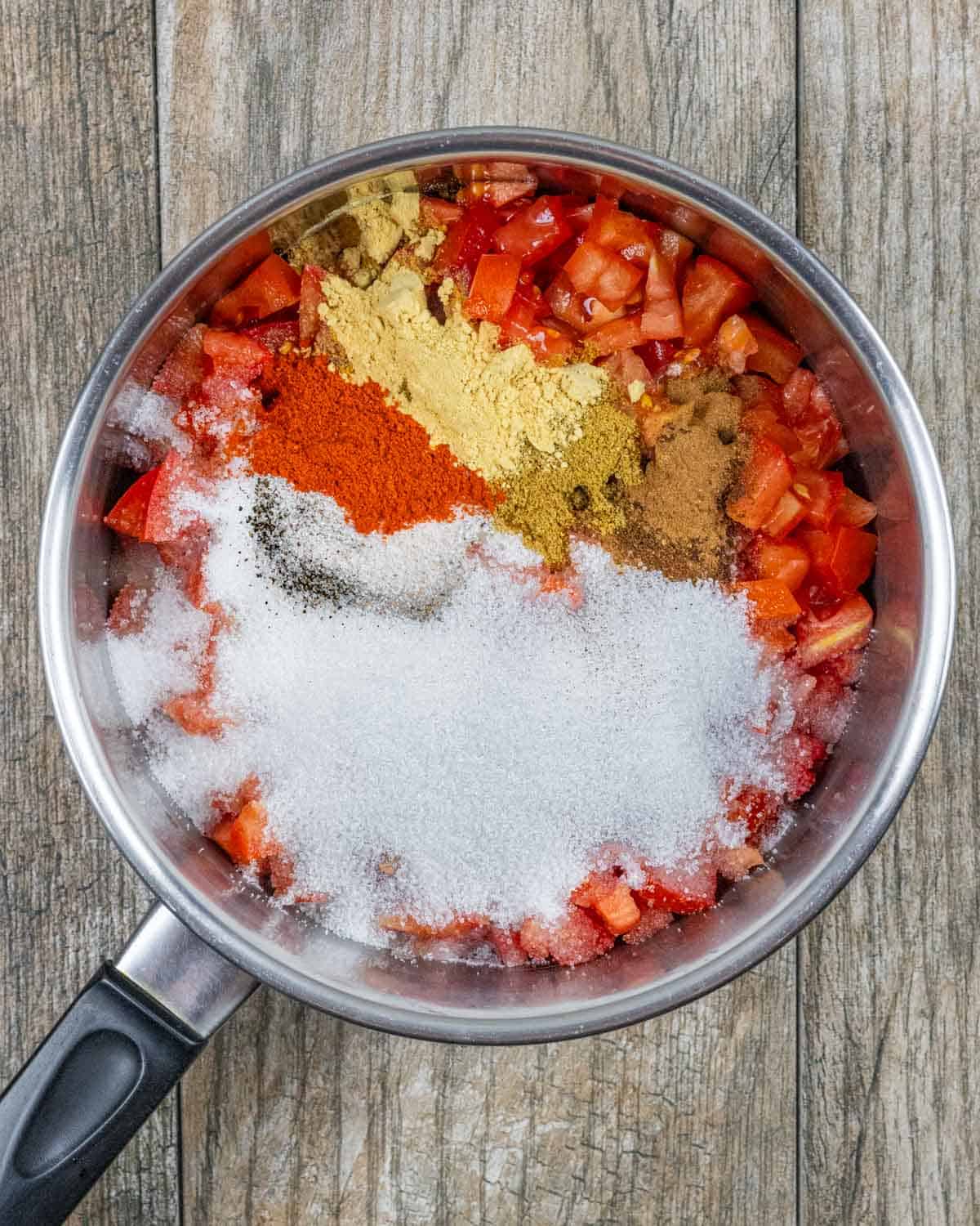 All ingredients for jam made from tomatoes and chili in a sauce pan ready to simmer.