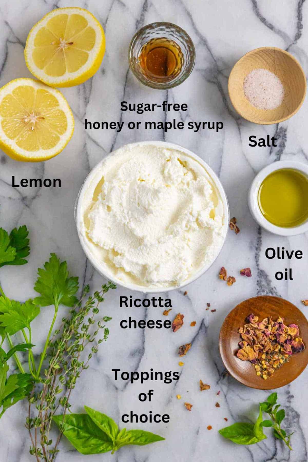 Ingredients for ricotta dip appetizer on a marble board with black text labels.